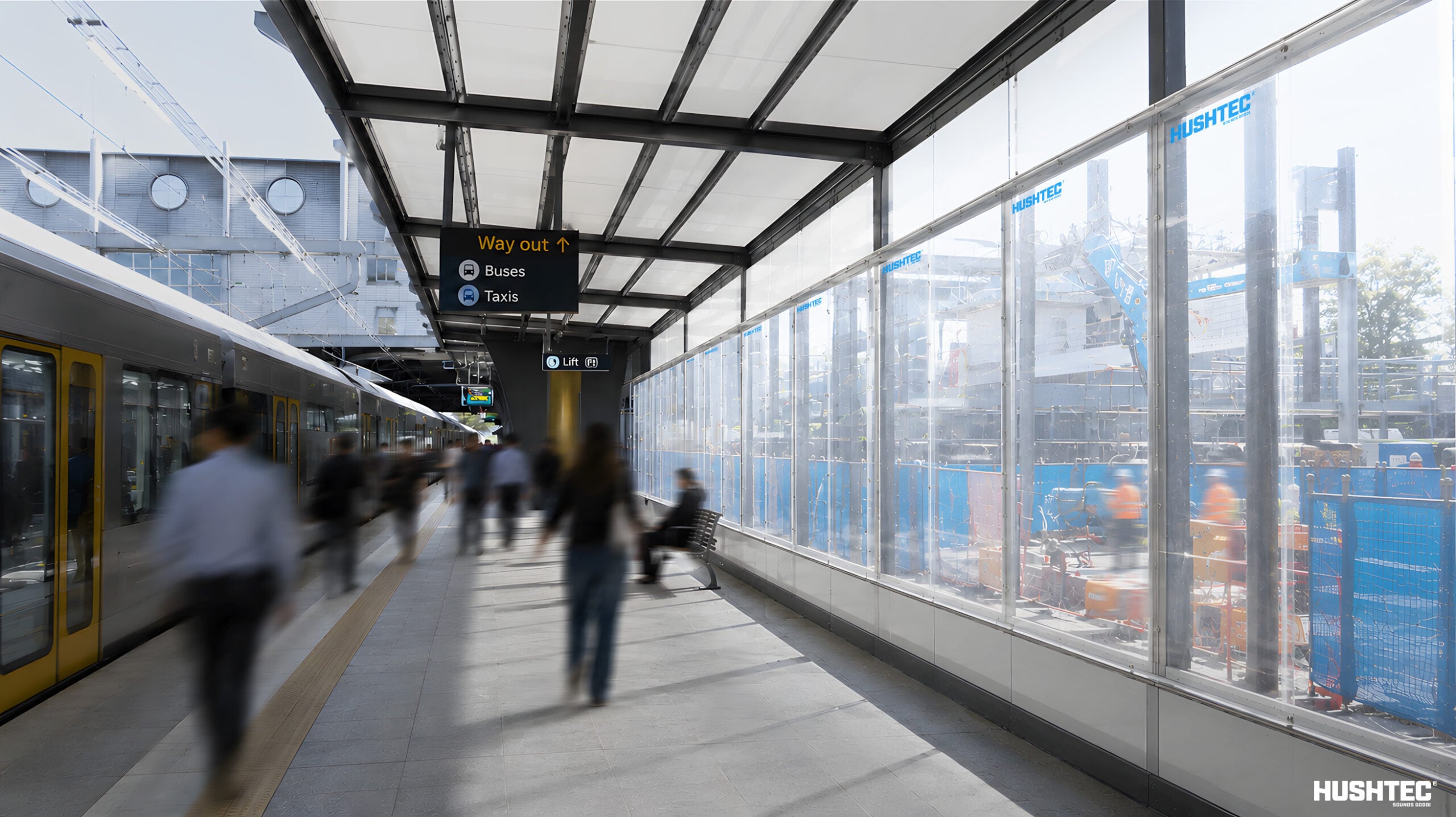 Transparent acoustic barrier at a modern rail station reducing train noise.